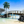 Tropical wooden bridge over clear blue water with palm trees and rocks, beach landscape