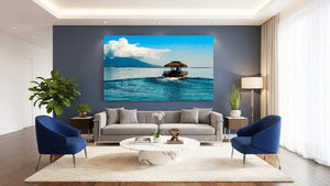 Modern living room with large wall art of a tropical boat on blue ocean, island in background
