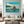 Modern living room with tropical boat wall art, staircase, and elegant neutral decor