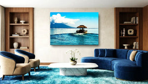 Modern living room with blue velvet sofa, armchairs, marble coffee table, and ocean landscape wall art.
