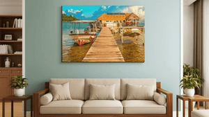 Wall art of a tropical pier with boats and thatched-roof hut, displayed above beige sofa
