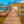 Wooden dock with colorful boats and thatched-roof hut over clear tropical water