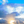 Sunrise with golden rays shining through dramatic clouds and a vibrant blue sky