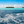 Tropical island with palm trees, turquoise water and blue ocean under a clear sky
