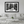 Framed black and white city street photo art displayed above modern white sofa in living room