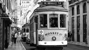 Vintage Lisbon tram on narrow city street, black and white urban photography
