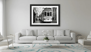 Modern living room with framed black and white city street tram wall art above sofa