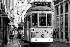 Black and white photo of Lisbon street with vintage tram and pedestrians