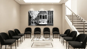 Modern waiting room with black chairs, glass table, and black and white city tram wall art