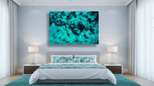 Modern bedroom with teal ocean abstract wall art above bed, matching decor and lamps