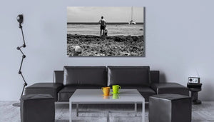 Modern living room with black sofa, colorful mugs and a seascape photo wall art