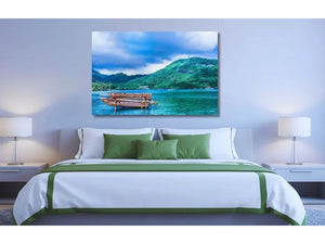 Modern bedroom with green-accented decor and large wall art of tropical lake and mountains