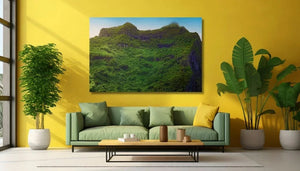 Modern living room with green sofa, indoor plants, and mountain landscape wall art