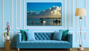 Blue sofa in elegant living room with ocean photography wall art, floor lamp, and plant