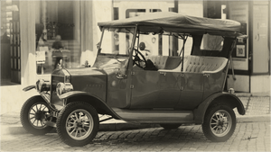 Vintage black and white photo of classic antique car parked on cobblestone street