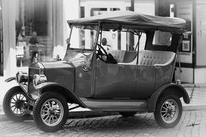 Monochrome fine art photo of a vintage car parked on a cobblestone city street