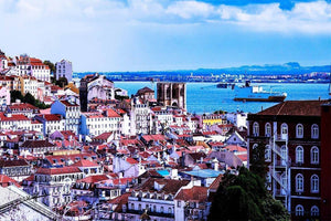 Scenic cityscape with orange-roofed buildings and river view under a bright sky