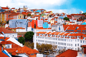 Panoramic view of colorful Lisbon buildings with red tile roofs and a city square statue