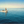 Small motorboat with three people on calm blue sea under clear sky
