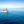 Three people riding a small motorboat on calm blue ocean under clear sky