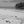 Black and white photo of a serene beach with palm trees and a lone person walking
