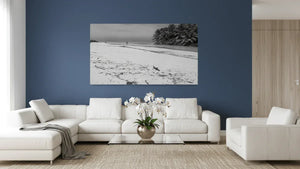 Modern living room with white sofas, blue wall, and beach landscape wall art