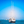 White sailboat anchored on calm blue sea with clear sky and distant boats