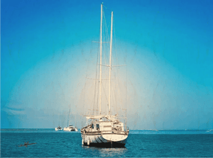 Sailboat anchored on calm blue sea with clear sky and distant boats