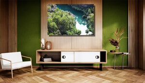 Framed river landscape photo with green trees displayed in modern living room decor