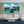 Modern living room with large yacht wall art, neutral sofa, blue rug, and green accent wall.
