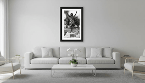 Modern living room with white sofa, framed black and white statue photo on wall, minimalist decor