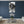 Black and white Polynesian statue art on wall in modern living room with blue accent wall.
