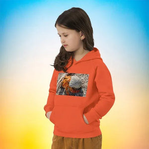 Child wearing orange eco-friendly hoodie with crab and shell print, gradient background