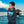 Child wearing navy eco-friendly hoodie with tropical island print by the water