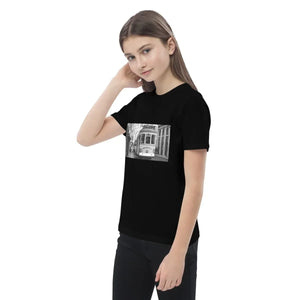 Child wearing black organic cotton t-shirt with vintage tram photo print.