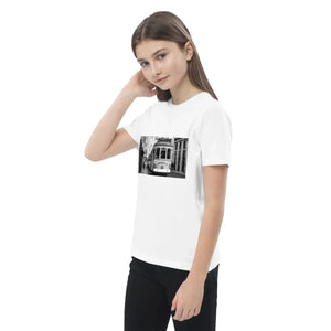 Girl wearing a white organic cotton kids' t-shirt with a black and white tram photo print