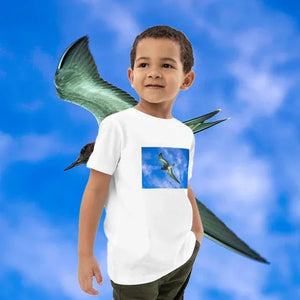 Child wearing white organic cotton t-shirt with bird print, standing against blue sky background