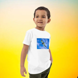 Child wearing white organic cotton T-shirt with flying bird print, yellow gradient background