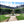 Tableau mural en plexiglas représentant une fontaine, le jardin et les façades de la place des Vosges à Paris sous un ciel bleu
