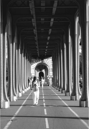 Image noir et blanc montrant une femme sous les arches du pont de Bir-Hakeim à Paris