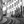 Black and white photo of curved urban street with tram tracks and people by historic buildings