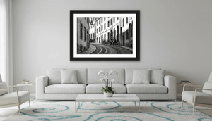 Modern living room with white sofa and a large framed black and white urban street photography print on the wall.