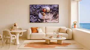 Modern living room with cream decor, coastal view, and wall art featuring hermit crabs in shells