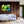 Modern living room with white sofa, wooden wall, and colorful abstract art on display