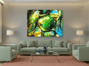 Modern living room with green sofas, glass coffee table, and vibrant abstract wall art featuring marine colors.