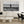 Modern living room with white sofa, marble coffee table, and large black and white seaside photo wall art.