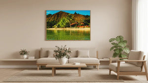 Framed tropical beach landscape photo on beige living room wall above neutral sofa