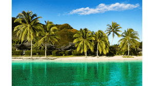 Tropical beach with palm trees, clear turquoise water, thatched huts, and blue sky