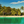Tropical beach with palm trees, turquoise water, and wooden bungalows under blue sky